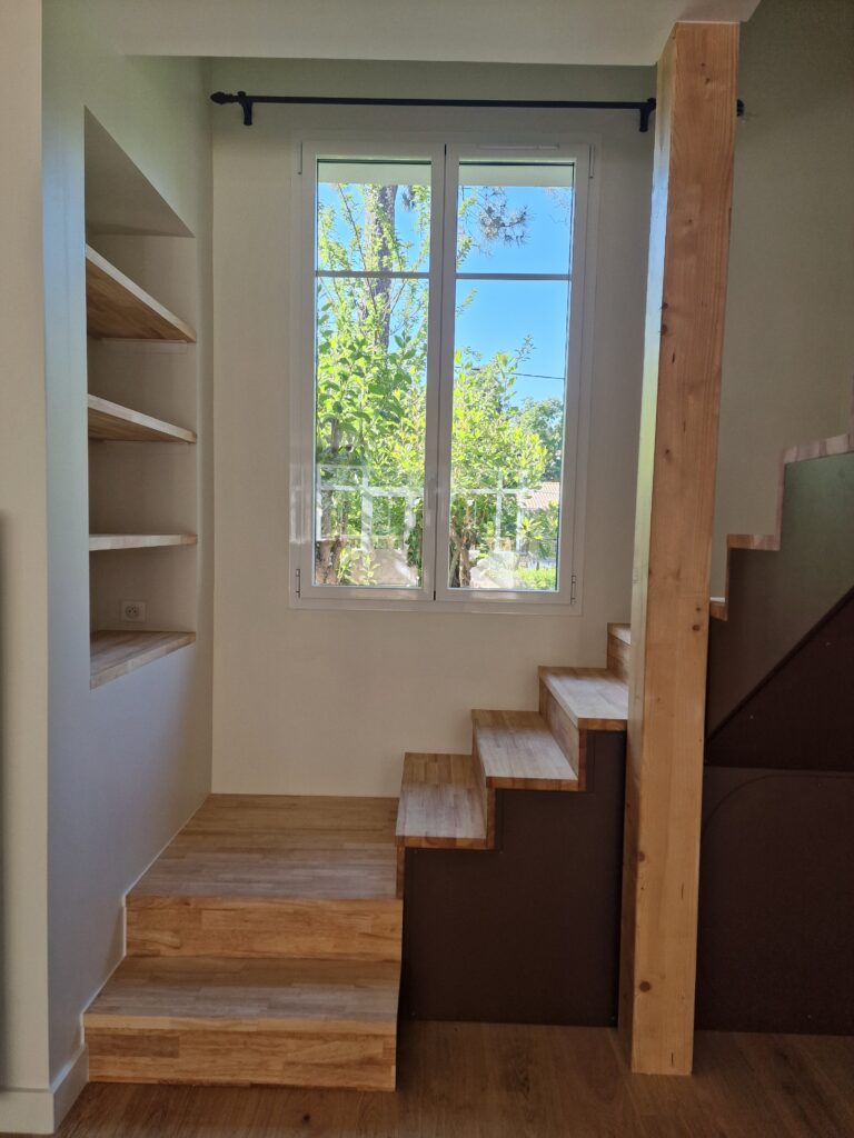 Escalier double quart tournant avec les marches et contremarches en chêne massif. L'autre partie de l'escalier est faite d'acier thermolaqué effet rouille.